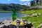 Green bottle and glass of natural Asturian cider made fromÂ fermented apples with view on Covadonga lake and tops of Picos de